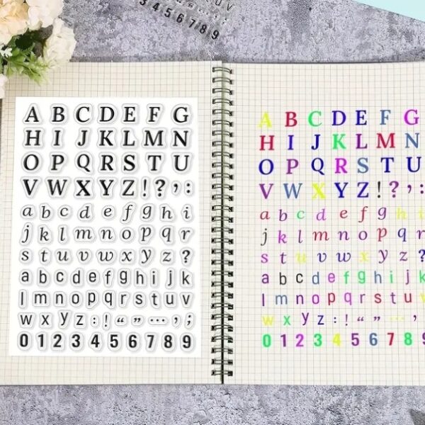 Two pages of a notebook displaying alphabet and number stickers in various styles and colors.